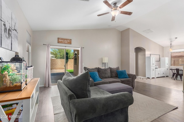 living room featuring vaulted ceiling, ceiling fan, and light wood-type flooring