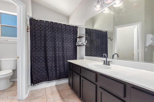 bathroom featuring toilet, tile patterned flooring, walk in shower, vaulted ceiling, and vanity