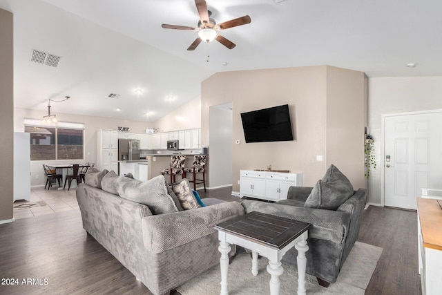 living room featuring ceiling fan, hardwood / wood-style floors, and vaulted ceiling