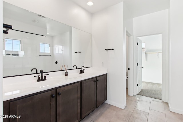 6641 N Desert Shadow Ln, Phoenix, AZ 85014 - bathroom with walk in shower, double vanity, tile patterned flooring, a spacious closet, and baseboards
