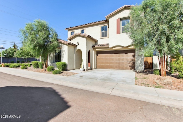 6641 N Desert Shadow Ln, Phoenix, AZ 85014 - mediterranean / spanish-style house featuring a tile roof, an attached garage, stucco siding, concrete driveway, and fence