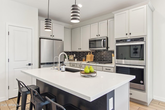 6641 N Desert Shadow Ln, Phoenix, AZ 85014 - kitchen with stainless steel appliances, a sink, backsplash, light wood-style flooring, and light countertops