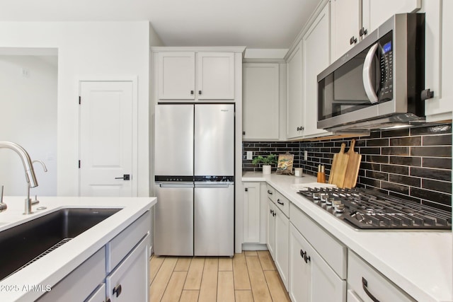 6641 N Desert Shadow Ln, Phoenix, AZ 85014 - kitchen with appliances with stainless steel finishes, a sink, backsplash, and light countertops
