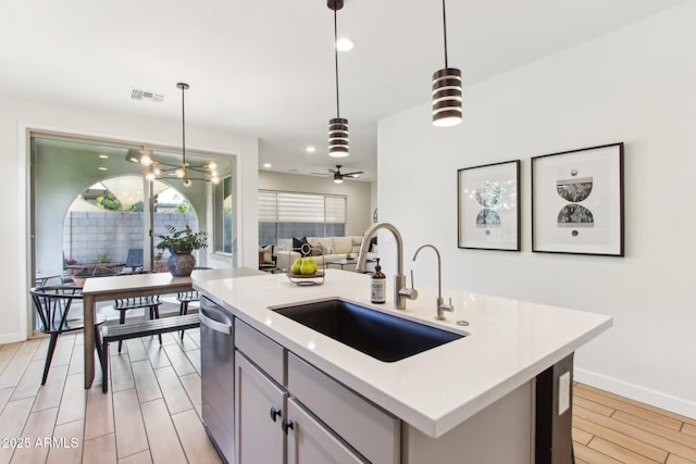 6641 N Desert Shadow Ln, Phoenix, AZ 85014 - kitchen featuring a sink, open floor plan, light wood finished floors, pendant lighting, and light countertops