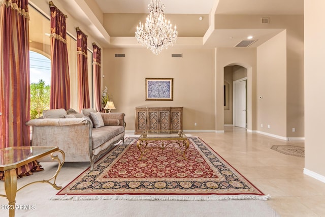 living room with a towering ceiling and an inviting chandelier