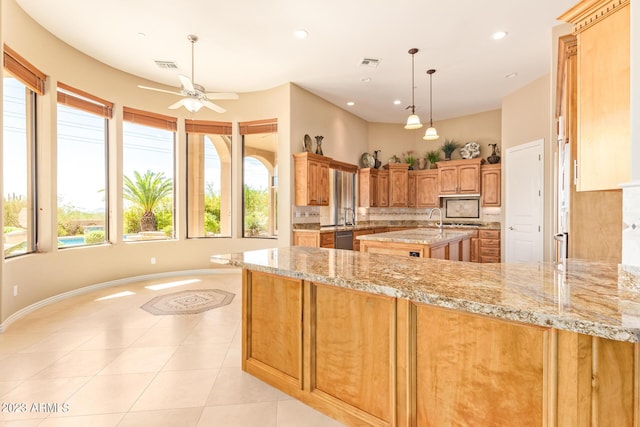 kitchen featuring light stone countertops, pendant lighting, backsplash, kitchen peninsula, and light tile patterned floors