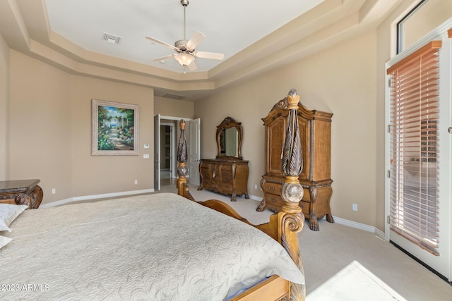 bedroom with ceiling fan, a raised ceiling, and light colored carpet