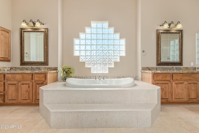 bathroom featuring tiled bath, tile patterned floors, and vanity