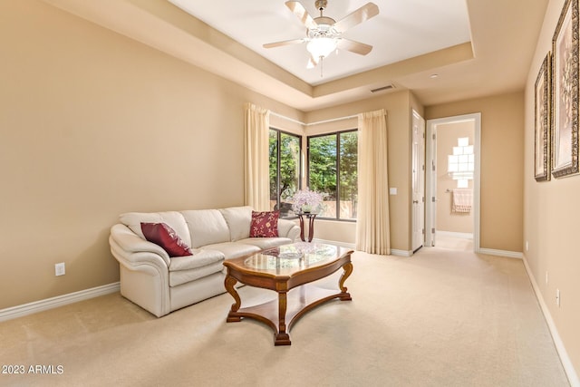 carpeted living room featuring ceiling fan and a raised ceiling