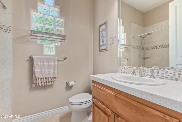 bathroom featuring backsplash, toilet, tile patterned floors, and vanity