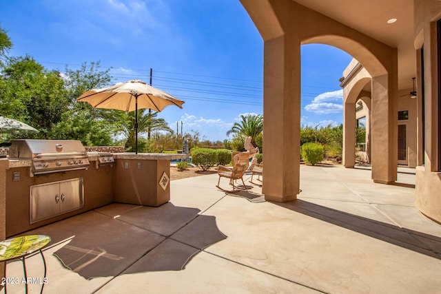 view of patio featuring exterior kitchen and a grill