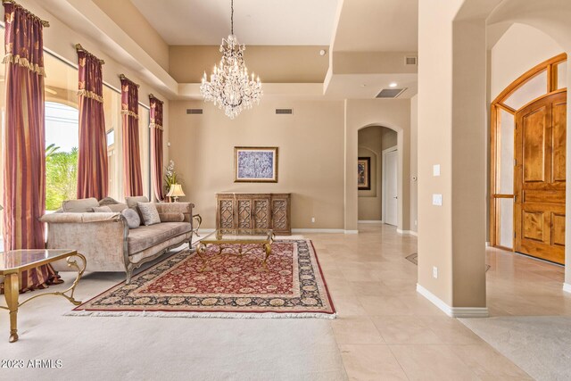 living room featuring an inviting chandelier, a towering ceiling, and light tile patterned floors