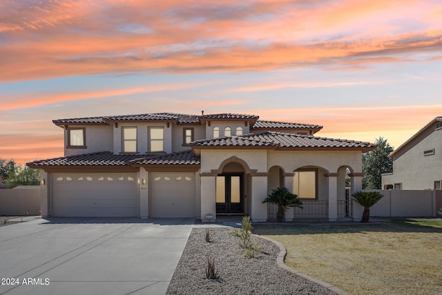 mediterranean / spanish-style home featuring a garage and a yard