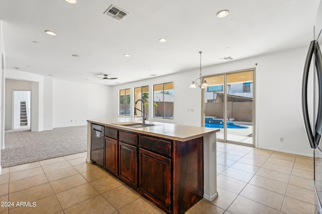 kitchen featuring ceiling fan, pendant lighting, a center island with sink, stainless steel appliances, and light tile patterned floors