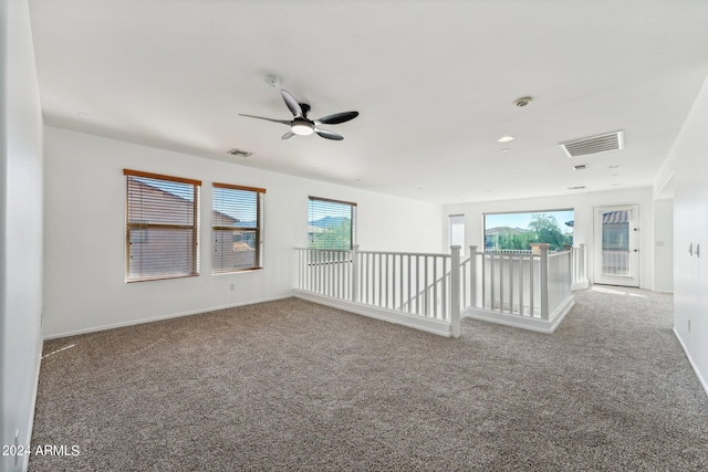 carpeted spare room with ceiling fan and a healthy amount of sunlight