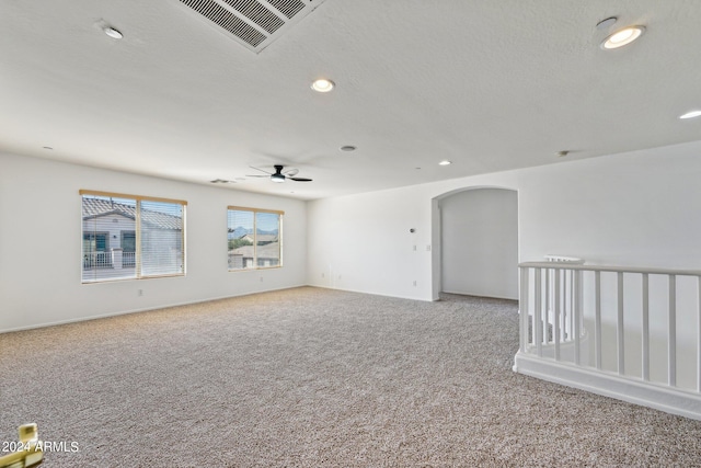 carpeted empty room featuring ceiling fan and a textured ceiling