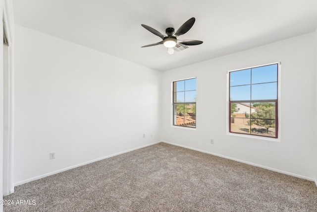 carpeted spare room with ceiling fan