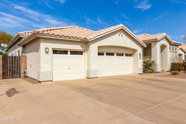 view of front of house featuring a garage, a tile roof, concrete driveway, and stucco siding