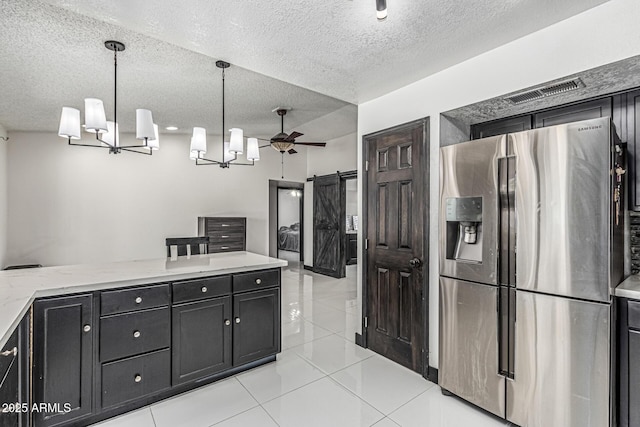 4020 W Anderson Dr, Glendale, AZ 85308 - kitchen with stainless steel refrigerator with ice dispenser, a textured ceiling, a barn door, dark cabinetry, and light stone countertops