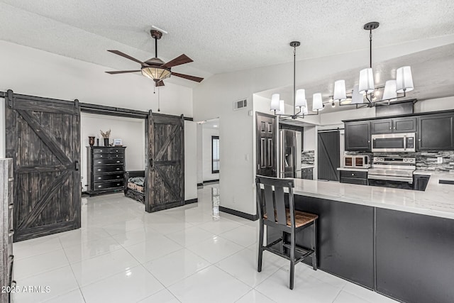 4020 W Anderson Dr, Glendale, AZ 85308 - kitchen with a barn door, appliances with stainless steel finishes, light stone countertops, vaulted ceiling, and a textured ceiling