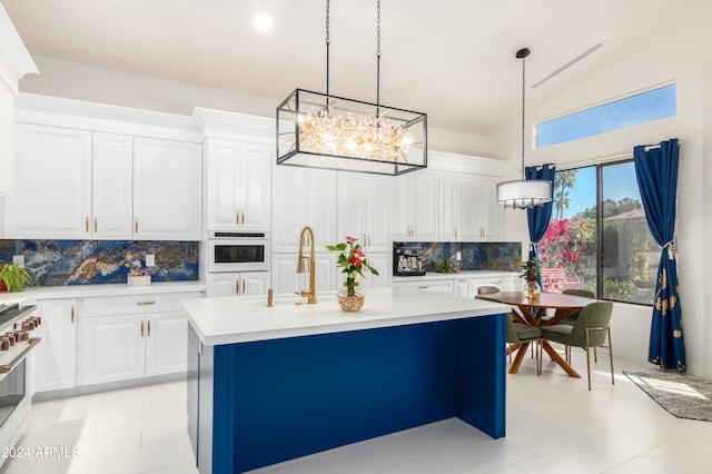 kitchen with white oven, white cabinets, decorative light fixtures, and backsplash