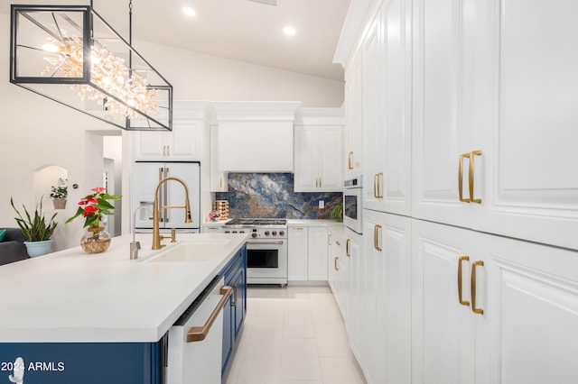 kitchen with white cabinets, a kitchen island with sink, white appliances, hanging light fixtures, and blue cabinetry