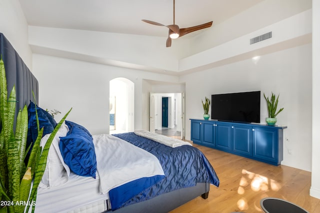 bedroom featuring ceiling fan, light hardwood / wood-style flooring, and high vaulted ceiling