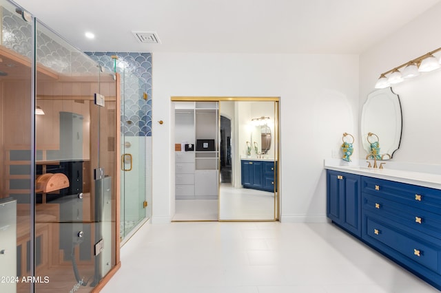 bathroom with tile flooring, vanity, and a shower with shower door