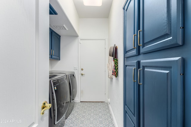 washroom with independent washer and dryer, cabinets, and light tile flooring