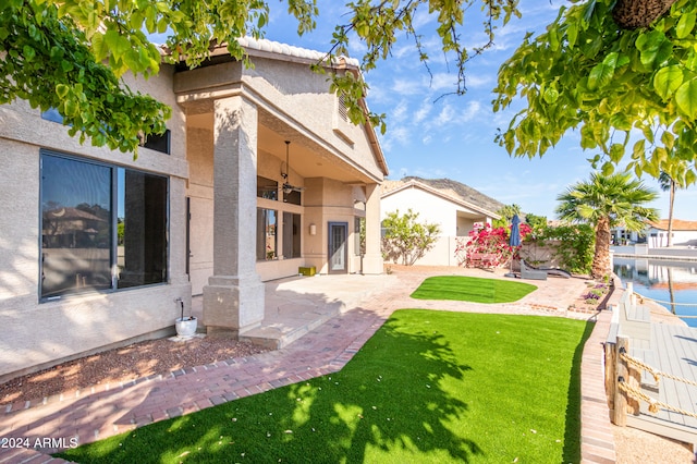 back of property with a patio area and a lawn