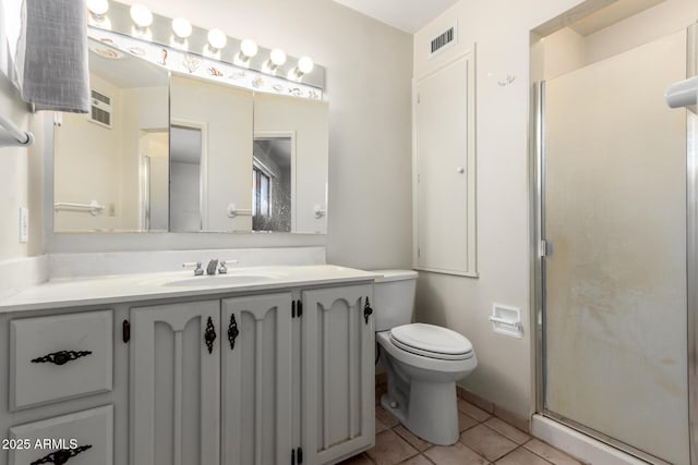 bathroom featuring a shower with door, vanity, tile patterned floors, and toilet