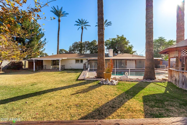 rear view of house featuring a lawn