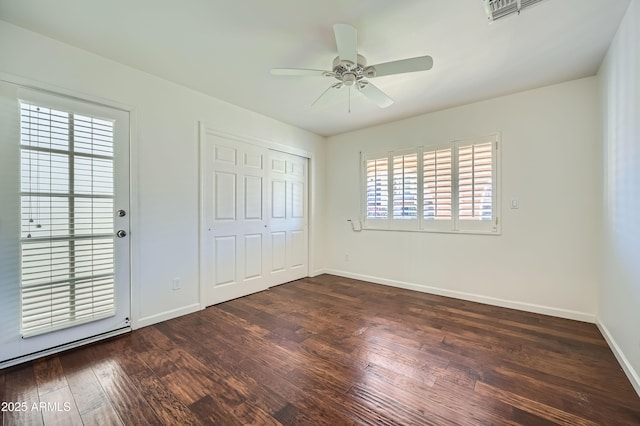 unfurnished bedroom with ceiling fan, a closet, and dark hardwood / wood-style floors