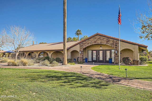 exterior space featuring a front lawn and french doors