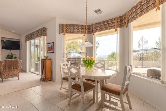 dining space featuring lofted ceiling, light tile patterned flooring, light colored carpet, visible vents, and baseboards