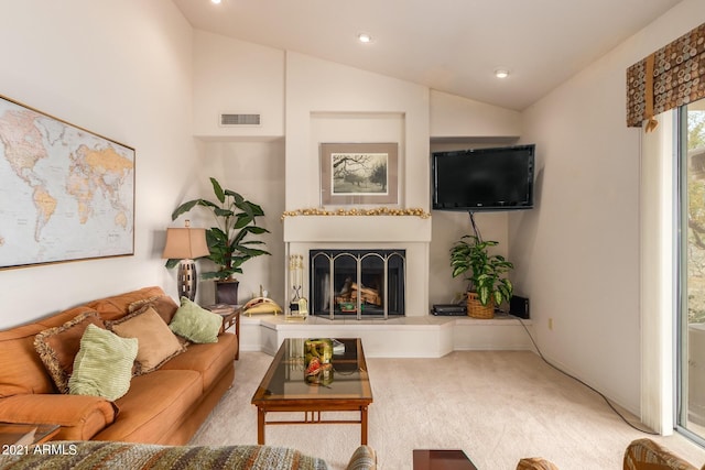 living room featuring a fireplace with raised hearth, carpet floors, lofted ceiling, and visible vents