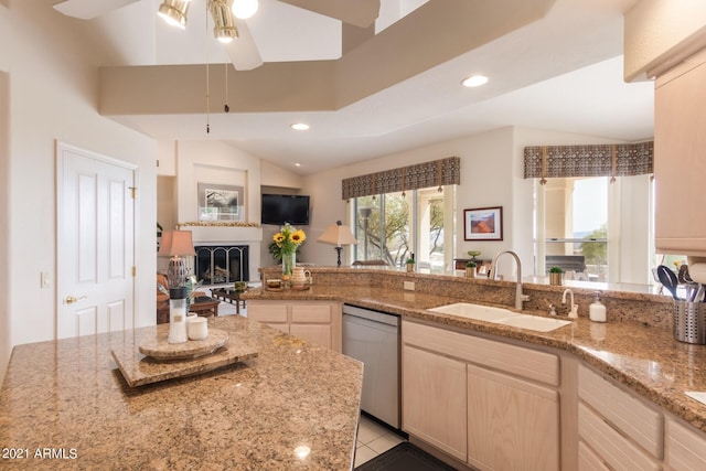 kitchen with dishwashing machine, light stone counters, a fireplace, a sink, and recessed lighting