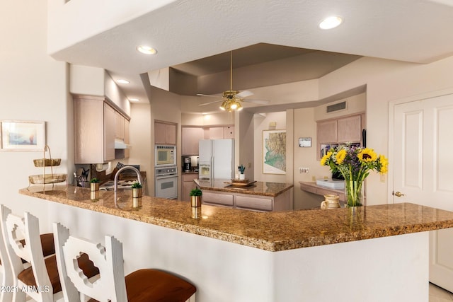 kitchen featuring white appliances, visible vents, ceiling fan, a peninsula, and recessed lighting