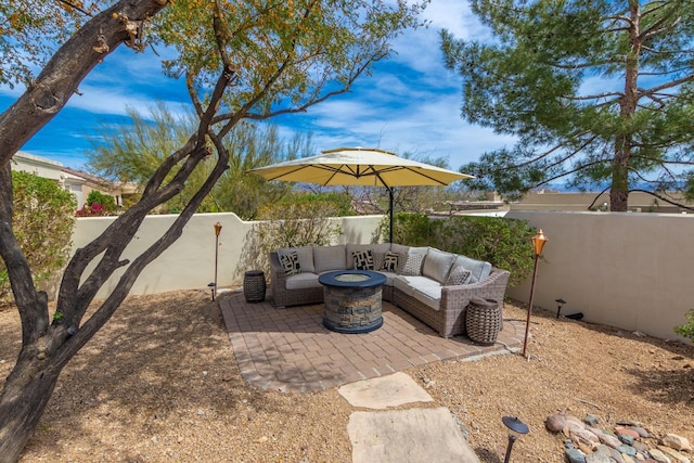 view of patio featuring a fenced backyard and an outdoor living space with a fire pit