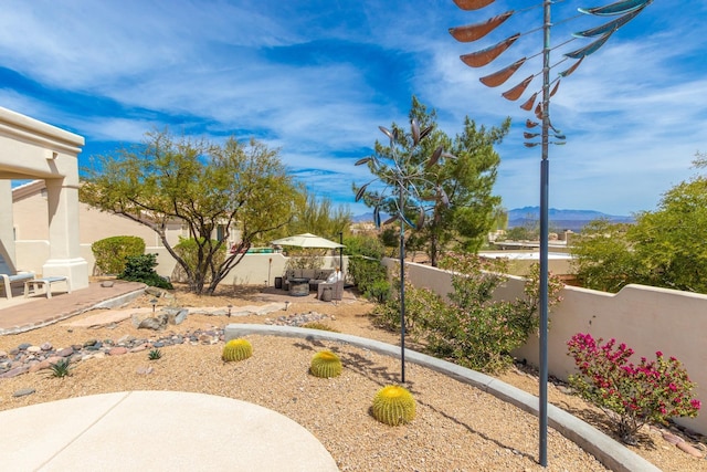 view of yard featuring a patio area, a fenced backyard, and a mountain view