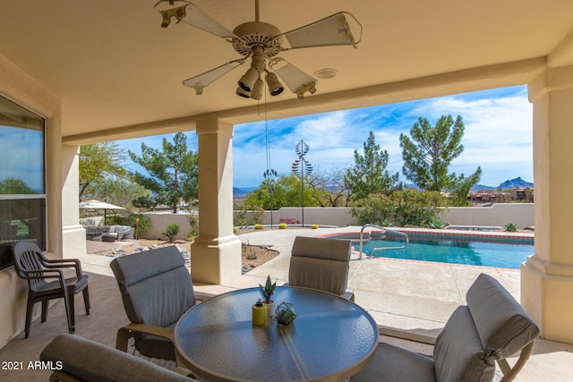 view of patio with a fenced in pool, outdoor dining area, a fenced backyard, and ceiling fan