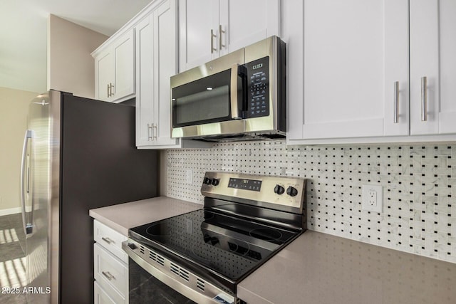 kitchen featuring white cabinets, appliances with stainless steel finishes, and tasteful backsplash