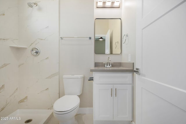 bathroom featuring vanity, toilet, and a tile shower