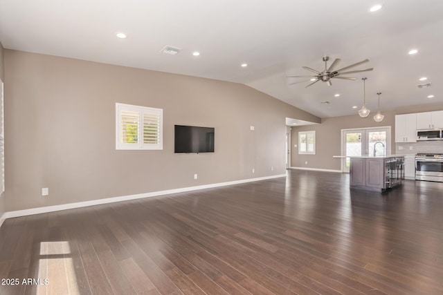 unfurnished living room with lofted ceiling, dark wood-style flooring, visible vents, and a sink