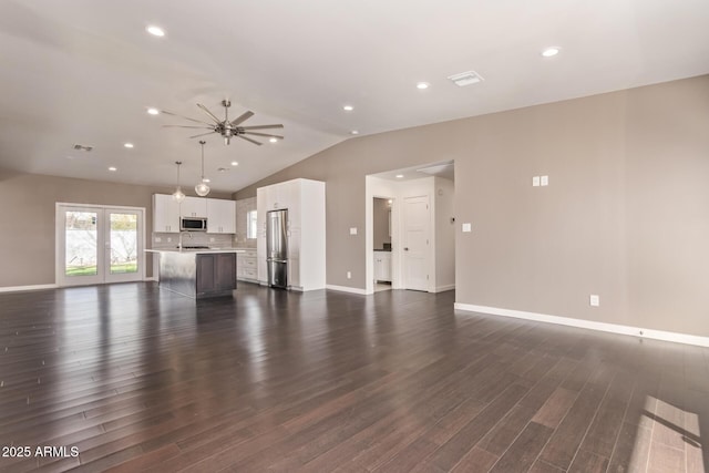 unfurnished living room with visible vents, baseboards, lofted ceiling, dark wood-type flooring, and recessed lighting