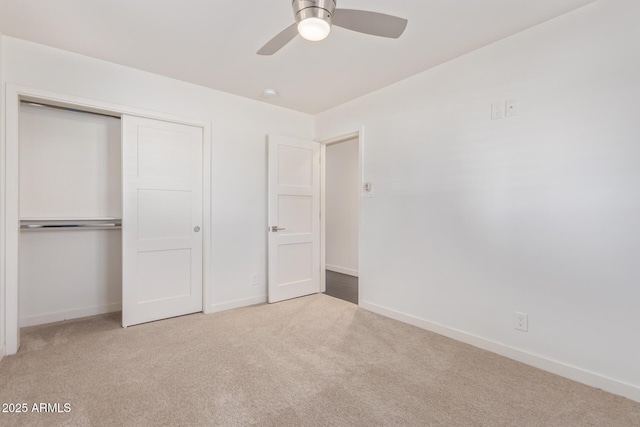 unfurnished bedroom with a closet, carpet flooring, a ceiling fan, and baseboards