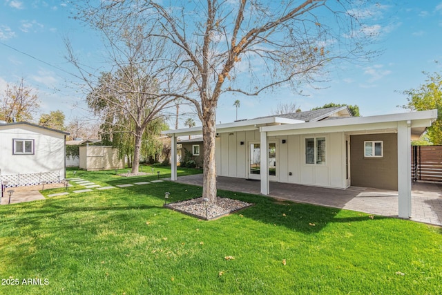 view of yard featuring an outbuilding, a patio area, fence, and a storage shed