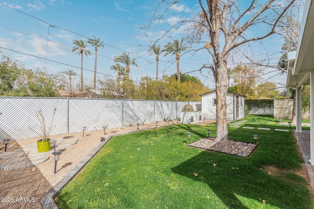 view of yard with a fenced backyard and an outbuilding