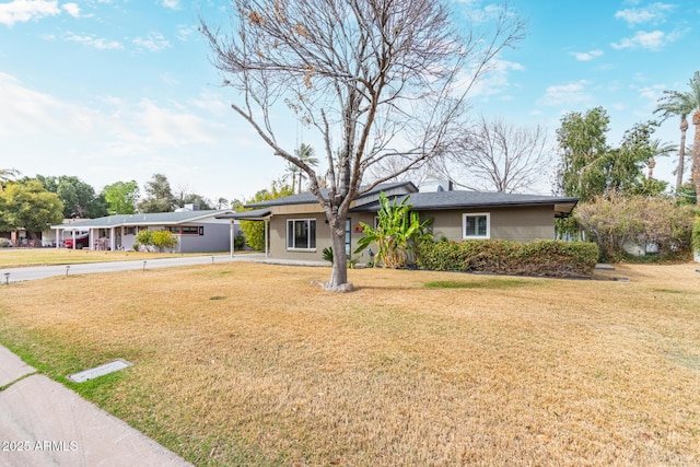 ranch-style house featuring a carport, concrete driveway, and a front lawn