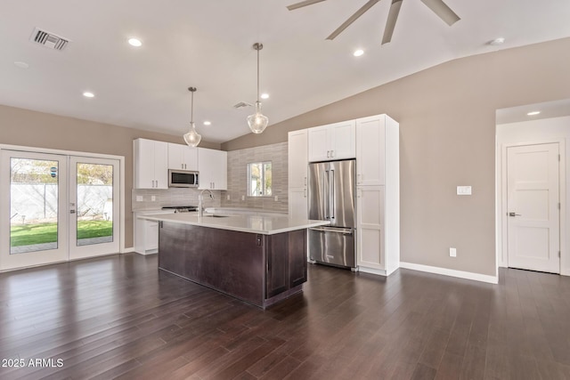 kitchen with a healthy amount of sunlight, stainless steel appliances, light countertops, and lofted ceiling